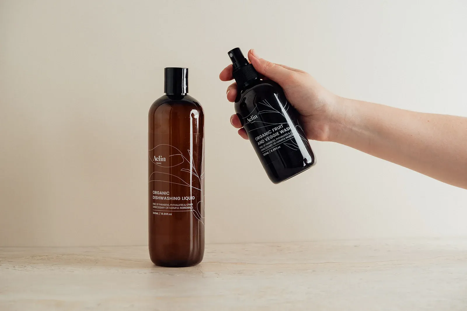 Aelin Organics bottle held against a neutral background